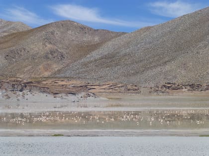 El lago de agua salada refleja el cielo y las montañas circundantes.