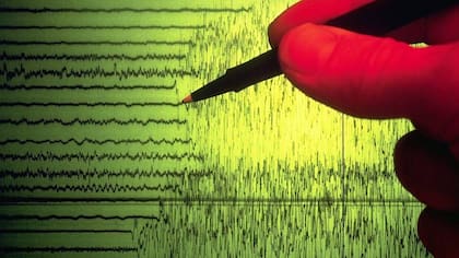 El lápiz marca el momento en un sismograma en que se capta el comienzo de un sismo.