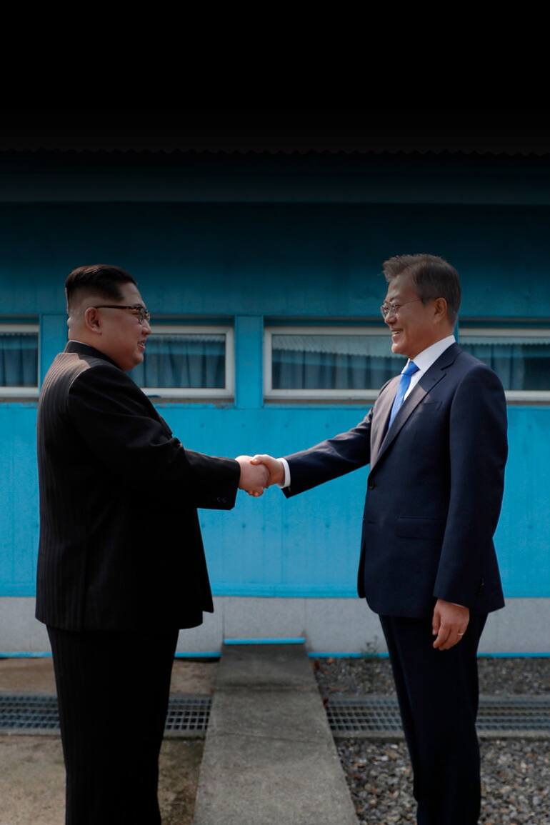 El líder de Corea del Norte Kim Jong Un le da la mano al Presidente de Corea del Sur, Moon Jae-in en la Línea de Demarcación Militar que divide a sus países antes de su cumbre por la tregua de Panmunjom el 27 de abril de 2018