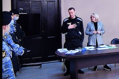 El líder de la oposición rusa Alexei Navalny se ve en una pantalla durante el veredicto en su juicio por malversación de fondos y desacato al tribunal en la colonia penitenciaria IK-2 en la ciudad de Pokrov en la región de Vladimir el 22 de marzo de 2022