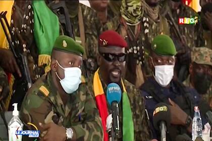 El líder del golpe militar de Guinea, coronel Mamad Doumbouya (centro, con anteojos para sol) ofrece un discurso en la capital Conakry el 6 de septiembre del 2021. (Radio Television Guineenne via AP)