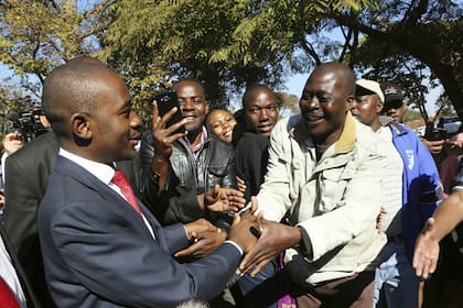 El líder opositor Chamisa, que denunció irregularidades en el proceso electoral, saluda a un grupo de partidarios tras votar en las afueras de Harare, la capital