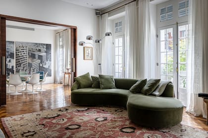 El living comedor tiene pisos originales de madera y ventanales que dan al frente de la calle Guido