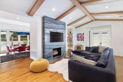 El living -con hogar y pisos de madera- se conecta con la cocina.