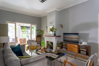 El living, luego de la renovación total. Mueble de la TV (Muebles Compadritos), maceta de bronce (Crate and Barrel). Apliques de luz al costado de la chimenea (La Rueda Antigüedades).
