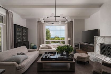 El living renovado con una nueva chimenea y una distribución que mejora la luminosidad del espacio