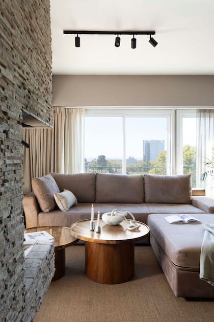 El living se estructuró a partir de un sillón en L diseñado a medida (Loft Design) para resolver la distribución y cumplir con dos funciones claras. Mesas ratonas (Indecasa). Objetos deco (Casa María Paula).