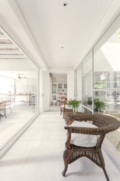El living y la cocina (al fondo) se comunican por un largo pasillo vidriado que tiene de un lado, el patio y, del otro, la galería.