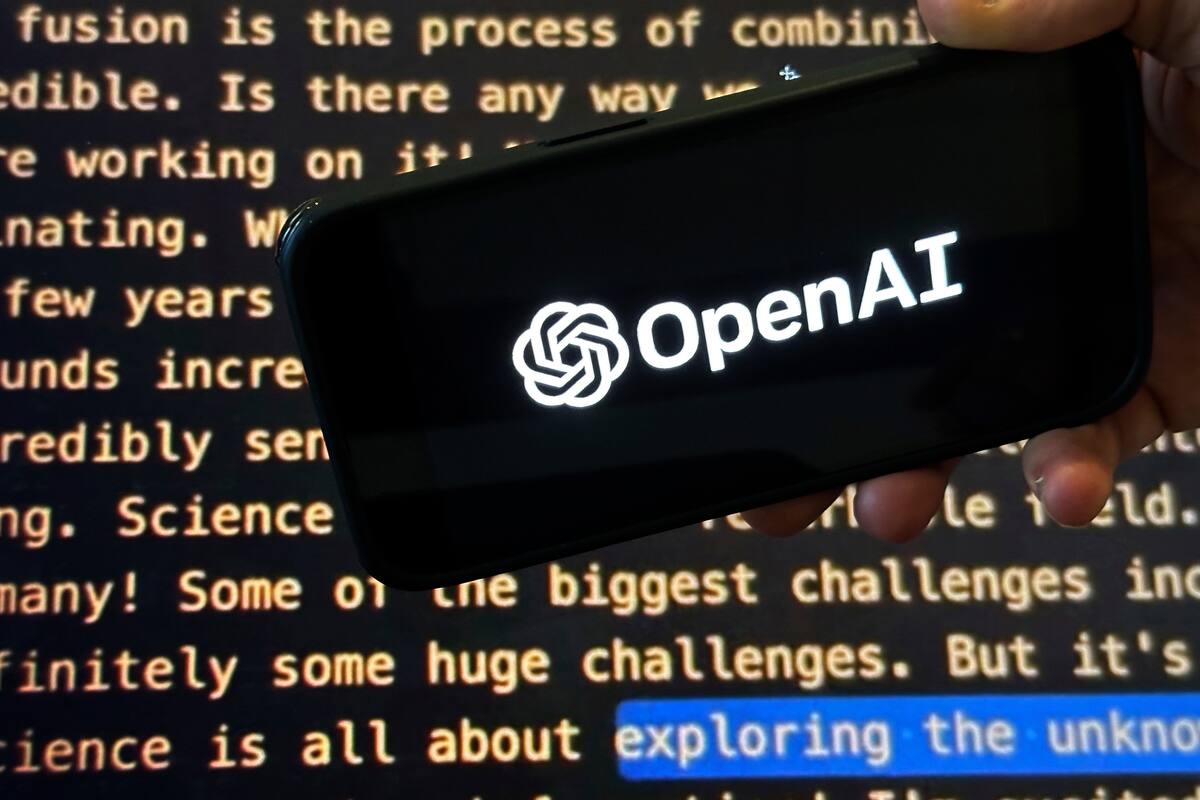 El logo de OpenAI en un teléfono celular frente a una pantalla que muestra el website de la compañía, en Nueva York el 21 de noviembre del 2023 (AP foto/Peter Morgan)