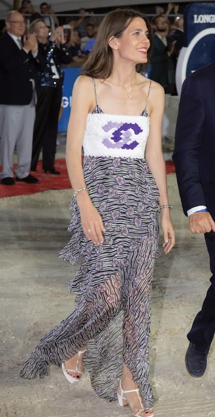 El look de Charlotte, perteneciente a la colección ready to wear Primavera/Verano 2022 de Chanel, consta de un vestido de gasa con estampado animal y detalles de flores sobre el que se luce un original top bandeau compuesto por "escamas" en tonos lilas y blancos.