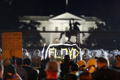 El martes en la noche, pese al toque de queda, una multitud seguía congregada frente a la Casa Blanca