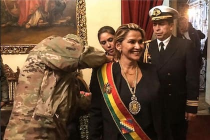 El máximo jefe militar coloca la banda presidencial a Jeanine Áñez