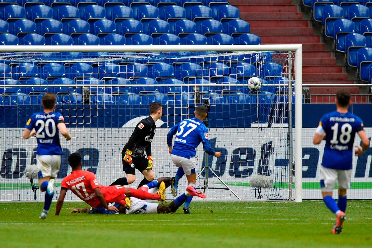 El mediocampista nigeriano de Augsburg Noah Sarenren Bazee (2ndL) marca el segundo gol de su equipo durante el partido de fútbol de la Bundesliga de la primera división alemana FC Schalke 04 v FC Augsburg el 24 de mayo de 2020