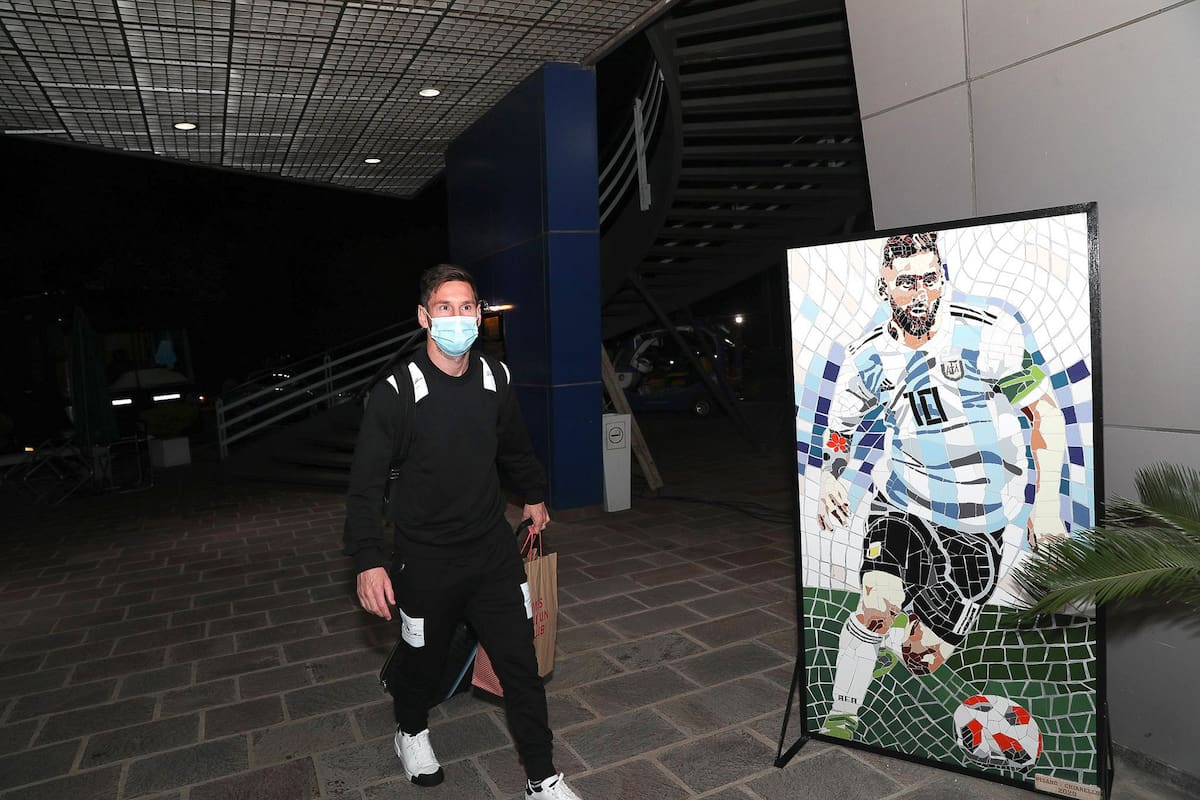 El Messi real, con barbijo, se cruza con el Messi del póster; máximo goleador histórico de las eliminatorias sudamericanas (junto con su amigo Luis Suárez), con 21 tantos, esta noche abrirá el camino rumbo a Qatar 2022