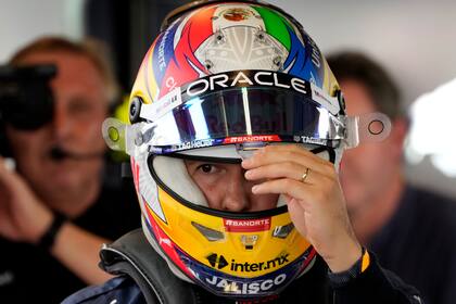 El mexicano Sergio Pérez, de Red Bull, se ajusta el casco durante la práctica del viernes 18 de noviembre de 2022, para el Gran Premio de Abu Dabi (AP Foto/Hussein Malla)