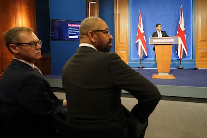 El ministro británico para la Lucha contra la Migración Ilegal, Michael Tomlinson (I) y el Secretario del Interior, James Cleverly, asisten a una conferencia de prensa con Sunak. Los conservadores impulsaron este año un polémico plan de relocalizar migrantes en Ruanda.