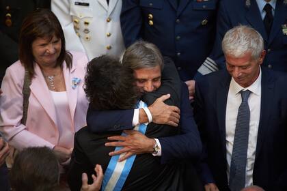 El ministro de Economía, Luis Caputo, abraza a el presidente, Javier Milei, luego de inaugurar el período de sesiones ordinarias del Congreso Nacional. 