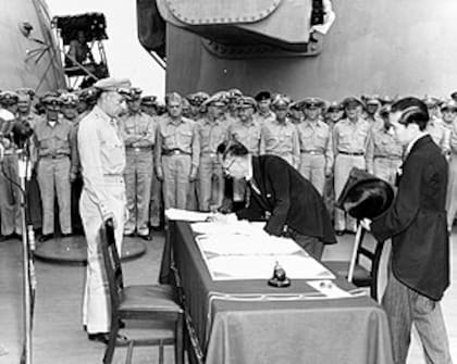 El ministro de exteriores japonés Mamoru Shigemitsu firma el Acta de Rendición de Japón a bordo del USS Missouri, mientras el general Richard K. Sutherland observa, 2 de septiembre de 1945.