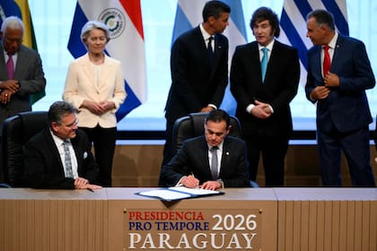 El Ministro de Relaciones Exteriores de Paraguay, Rubén Ramírez Lezcano, firma un documento junto al Comisionado Europeo de Comercio y Seguridad Económica, Maros Sefcovic. (Photo by Luis ROBAYO / AFP)
