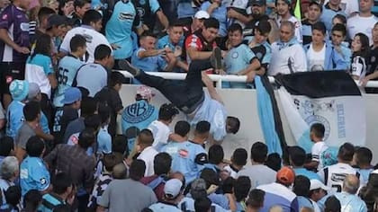 El momento en el que Balbo cae de la tribuna; lo empujan Martín Vergara (de rojo), Cristian Oliva (de gorra blanca), Pablo Robledo (el primero parado a la derecha de Oliva) y Matías Oliva (parado al lado de Robledo)