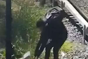 El momento en el que el delincuente intenta robar los cables de las vías del tren