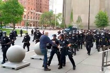 El momento en el que los dos policías empujan al hombre, mientras la infantería avanzaba