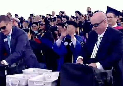 El momento en el que sacan los sobres brindados por Robert Hale para dárselos a los estudiantes