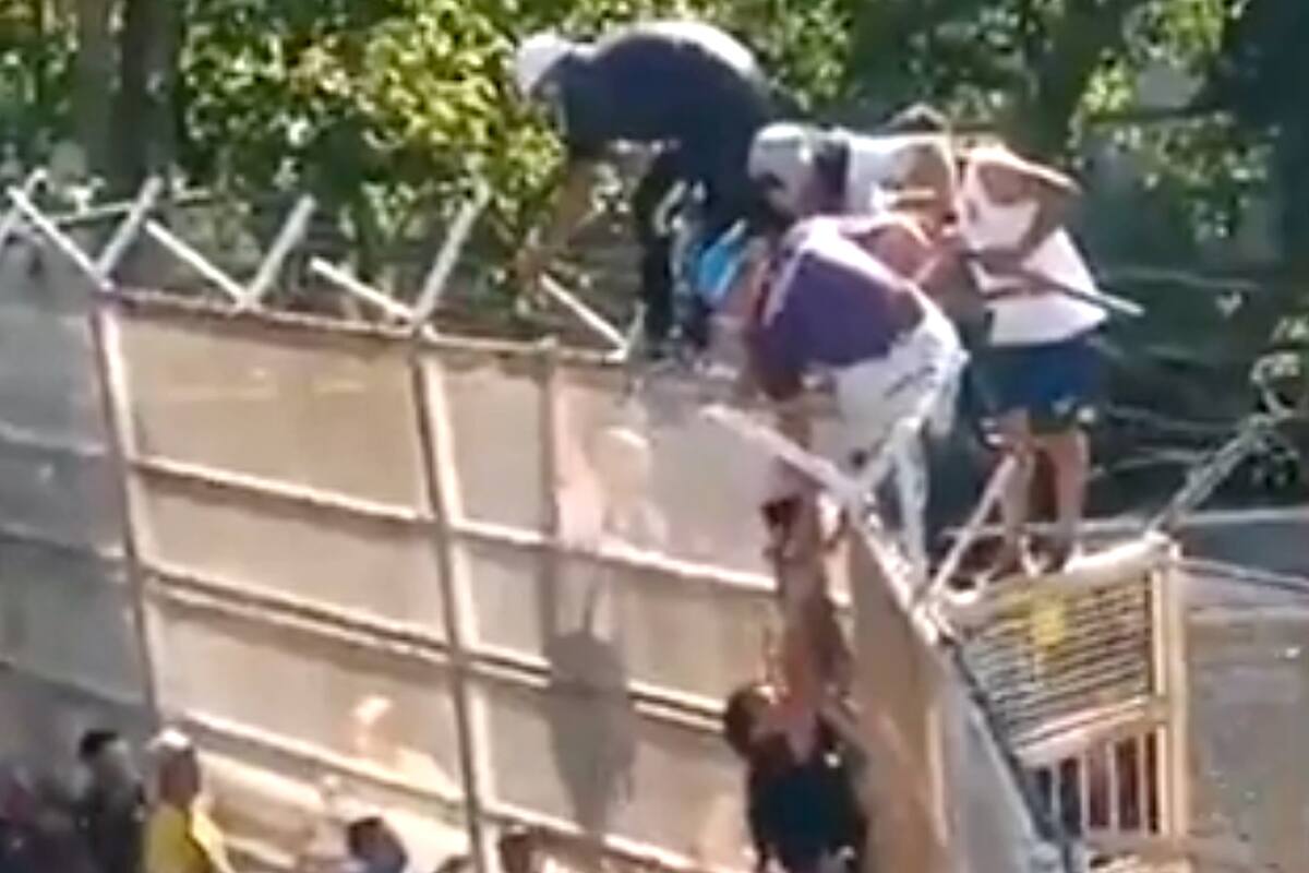 El momento en el que suben a la niña por arriba de la reja.