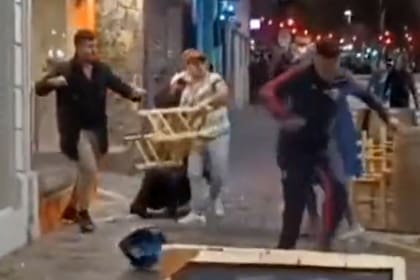 El momento en el que un comensal toma una silla y agrede a otros a las afueras de un bar mendocino