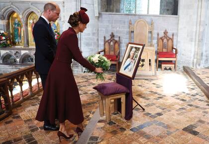 El momento en que depositan un ramo de flores junto al retrato de la Reina.