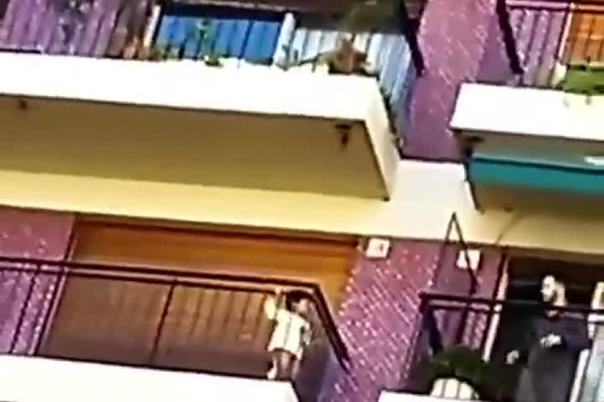 El momento en que el encargado del edificio cruza un balcón para rescatar al menor