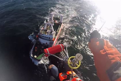 El momento en que el marinero infartado es izado en una canasta de rescate hasta el helicóptero de la Prefectura