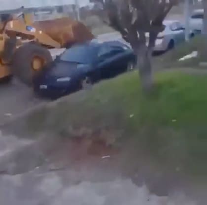 El momento en que la retroexcavadora pasa por encima de uno de los autos estacionados