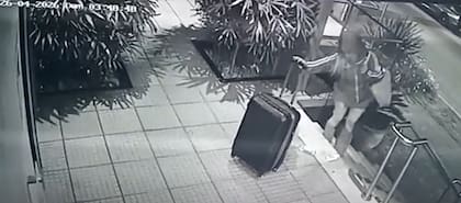 El momento en que la "viuda negra" sale del edificio de su víctima con el botín en una valija