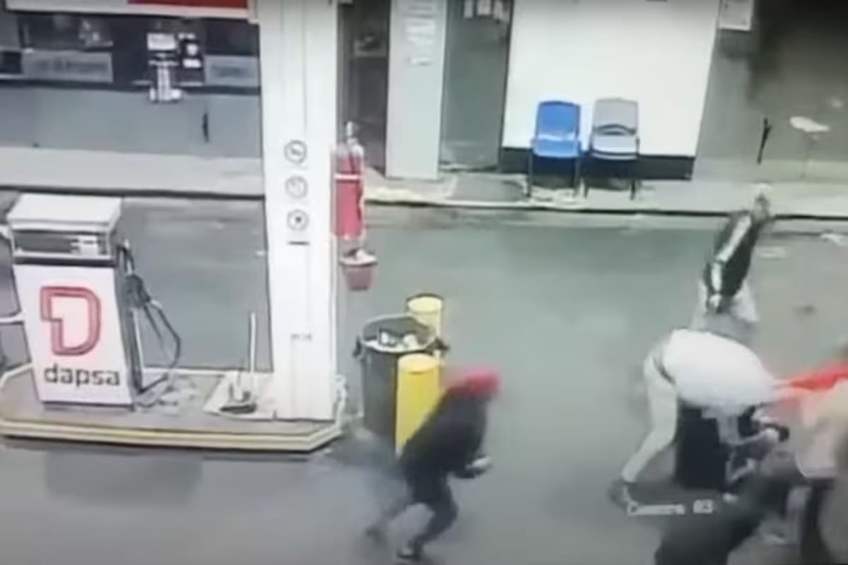 El momento en que uno de los atacantes se prepara para lanzar una piedra en la cabeza de Adrián Bustamante