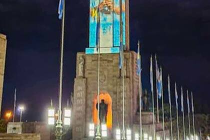 El Monumento a la Bandera con los colores patrios y la figura de Leo Messi