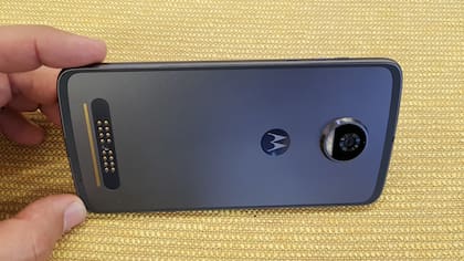 El Moto Z2 Play cambia el vidrio trasero por metal; a la izquierda, los conectores magnéticos para los accesorios