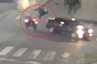 Cruzó en rojo con su moto, chocó contra un auto y voló por el aire