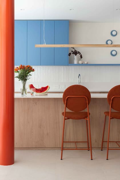 El mueble de cocina diseñado por Bouré Studio combina melamina ‘Roble Kendal Natural’ (Egger) y secciones laqueadas en azul Dyer’s Woad 9071 de Sherwin Williams. Banquetas (The Pink Chair).