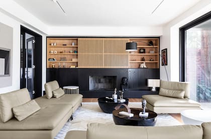 El mueble de roble de Eslavonia y paraíso lustrado en negro es un diseño del arquitecto Radovic (foto) ejecutado por Woodhead Studio; ocupa todo el plano, incluido el hogar recuperado. Detrás del panel varillado corredizo, está la TV.