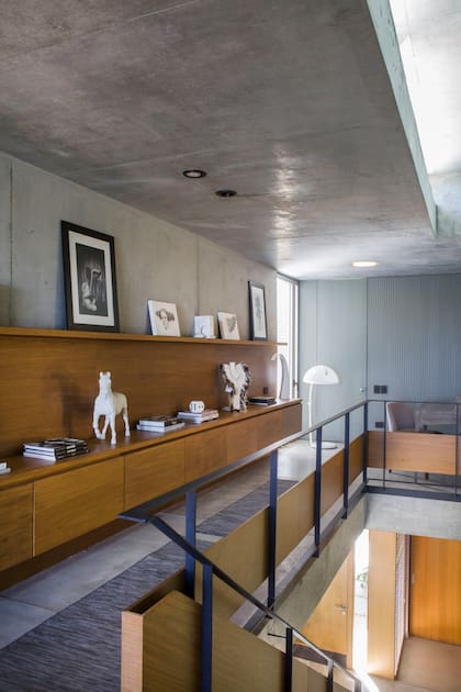 El mueble flotante existente también fue revestido en madera. Para darle más relevancia, sumaron la alzada y, como remate, el estante, donde hay fotos hechas por Daniela. Figura de caballo (Plant the Future). Lámpara de pie años 50.