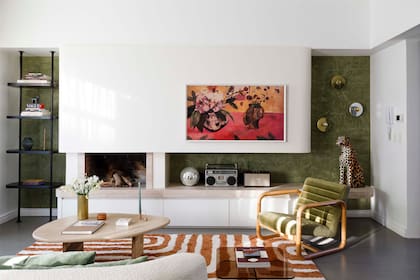 El mueble que contiene la chimenea y es un diseño de Ortiz hecho con placa de yeso, Travertino y estuco verde. Sillón vintage restaurado por Muebles Compadritos, con pana de De Levie. Alfombra ‘Shabby Plush Laberinth Cobre’ (Mihran).