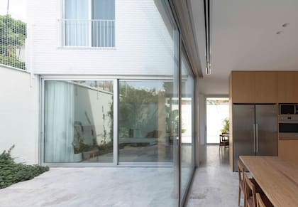 El mueble que divide la cocina del comedor es diseño del Estudio y se hizo en MDF enchapado en roble.