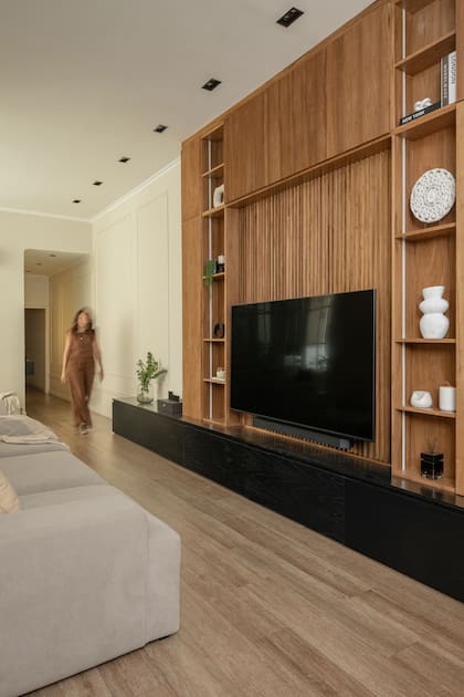 El mueble recorre el ambiente y lo organiza. Para materializarlo se eligió un enchapado en madera de petiribí con una base laqueada poro abierto (Romano Cal)