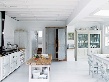 En la cocina, el mueble tipo despensa, junto a la envidiable colección de cacerolas blancas, esconde la heladera.