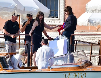 El músico y actor Malcolm McRae llega en una lancha con el traje de Dior que luego usará para su casamiento.