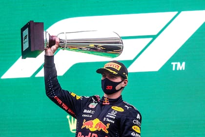 El neerlandés de Red Bull, Max Verstappen, celebra con su trofeo en el podio después de obtener el primer lugar en el Gran Premio de Bélgica de Fórmula 1, en una jornada pasada por agua
