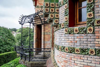 El orignal balcón de El Capricho, diseñado en hierro forjado con pérgola y asiento.