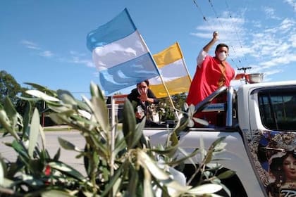 El padre "Lalo" Carreras, reconocido en Mendoza; ahora dando las bendiciones de ramos en Salta, a bordo de una camioneta, y con barbijo.
