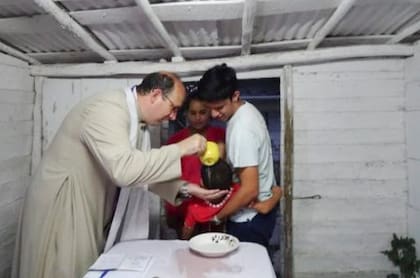El padre Jorge Herrera, que acompaña al padre Carlos Peteira, en la misión de Yaguajay, celebra un bautismo
